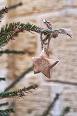 Closeup wooden star on Christmas tree branch. handmade Christmas zero-waste ornaments