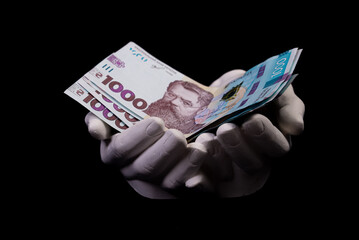 two hands with hryvnias. Closeup female hand giving money for something with isolated on black background,count, paying, shopping with hryvnias, corruption, counting hryvnias banknotes Ukraine