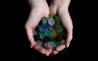 hands with colored stones Young woman is holding a collection of various raw mineral gemstones in her palm isolated on black