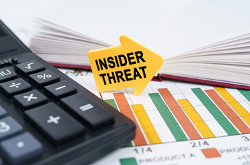 On the business charts there is a notepad, a pen and an arrow sticker with the inscription - Insider Threat