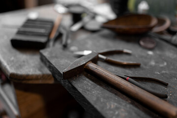 Three handmade bracelets are resting on top of the jeweler work table