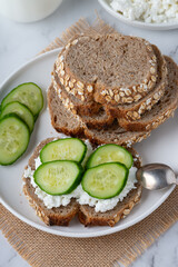 Slices of rye bread with cottage cheese and cucumbers