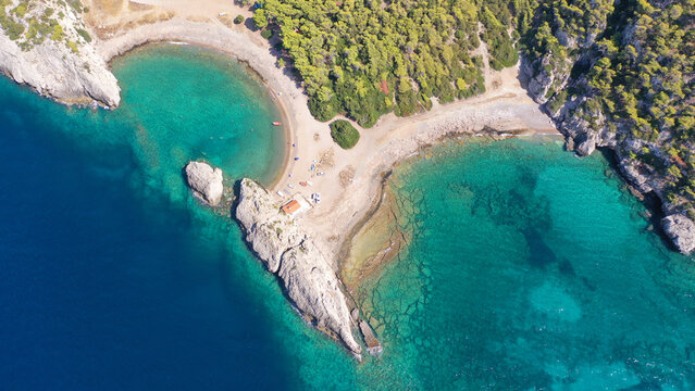 Aerial drone top down photo of scenic half moon shaped crystal clear sea beach of Milokopi near famous lake Vouiagmeni, Loutraki, Perachora, Greece