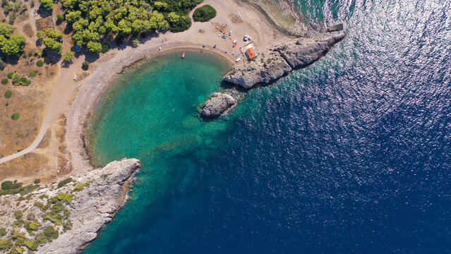 Aerial drone top down photo of scenic half moon shaped crystal clear sea beach of Milokopi near famous lake Vouiagmeni, Loutraki, Perachora, Greece