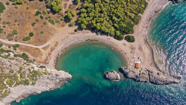 Aerial drone top down photo of scenic half moon shaped crystal clear sea beach of Milokopi near famous lake Vouiagmeni, Loutraki, Perachora, Greece
