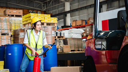 Group of warehouse worker holding a fire extinguisher for prepares for dangerous situations in warehouse factory.
