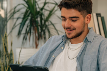 young man at home with tablet or laptop