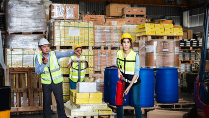 Group of warehouse worker holding a fire extinguisher for prepares for dangerous situations in...