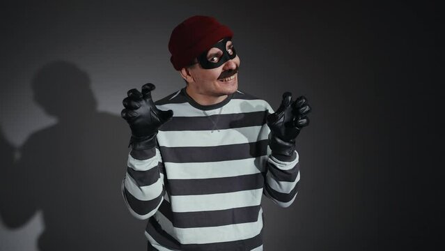 scary and funny bandit in mask scares and looks at the camera