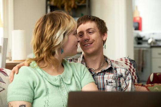 Non Binary LGBTQ+ Couple sitting on couch relaxing