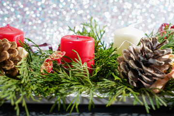 Christmas with red candles and christmas tree balls and fir branches and pine cones