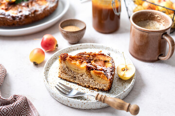 Homemade tarte tatin pie with apples and nuts on a beige background. French apple pie, selective focus.