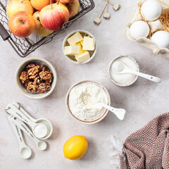 Ingredients for a sweet apple pie on a stone light background. View from above.