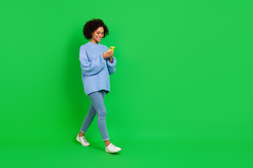Fototapeta na wymiar Full length photo of funny wavy lady look telephone go wear pullover jeans boots isolated on green color background