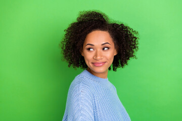 Photo of pretty nice cute woman with wavy hairstyle dressed blue sweater looking at empty space isolated on green color background