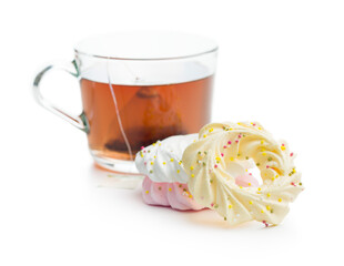 Different colors meringues with sprinkles and tea isolated on white background.