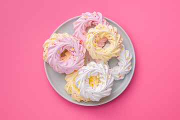 Different colors meringues with sprinkles on plate. Top view.