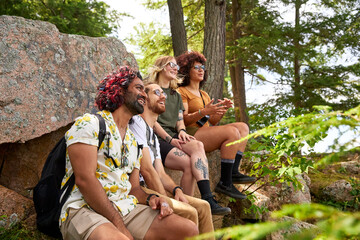 Fototapeta premium Two LGTBTQ+ couples realxing beside a lake while hiking