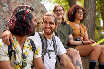 Two LGTBTQ+ couples realxing beside a lake while hiking