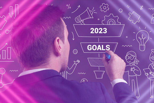 Business, Technology, Internet and network concept. Young businessman working on a virtual screen of the future and sees the inscription: 2023 goals