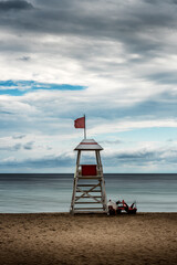 Sea sandy beach and white wooden watchtower (rescue post)