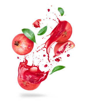 Sliced pomegranate with juice splashes in the air isolated on a white background