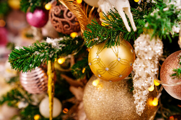 A part of Christmas tree with gold decor in a classic style.