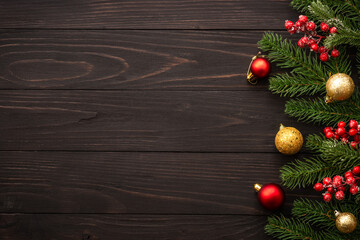 Christmas background on wooden. Fir tree brunch and red decorations flat lay with copy space.