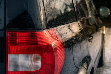 black cars backside in sunlight. cars rear light.