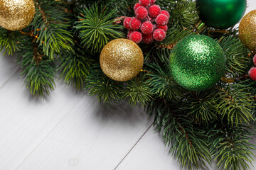 beautiful branches of a Christmas tree with cones and toys on a white wooden background with the inscription Merry Christmas