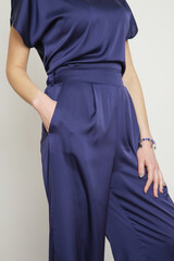 Serie of studio photos of young female model in dark blue silk outfit.	