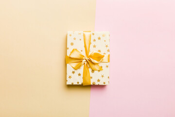 holiday paper present tied yellow ribbon bow top view with copy space. Flat lay holiday background. Birthday or christmas present. Christmas gift box concept with copy space