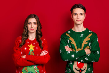 Portrait of two concentrated focused people folded hands calm face isolated on red color background