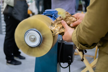 Professional man carpenter hands using belt sander machine, polishing wood product at workshop -...