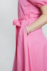 Series of studio photos of young female model in bright pink midi dress