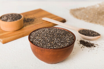 Chia seeds in bowl and spoon on colored background. Healthy Salvia hispanica in small bowl. Healthy superfood