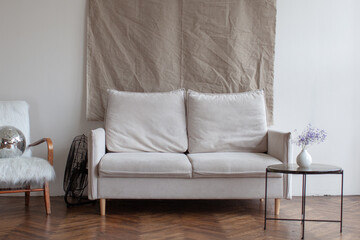 Retro interior with white sofa. White chair and wooden floor.