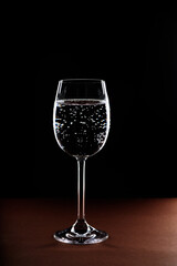 Glass of drink water with gas on black background.