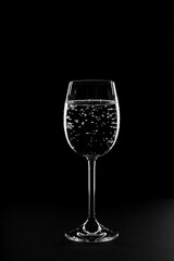 Glass of drink water with gas on black background.