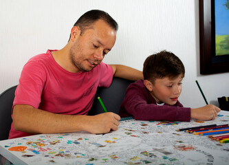 Dad teaches his son how to paint.