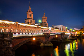 Fototapeta na wymiar Illuminated Oberbaum bridge in Berlin at night with reflections