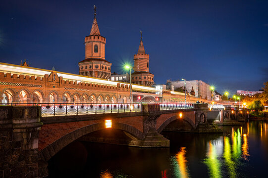 Illuminated Oberbaum bridge in Berlin at night with reflections