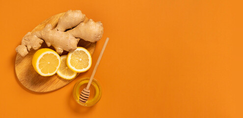 Fresh ginger root lemon honey orange background. Alternative medicine vegetarianism