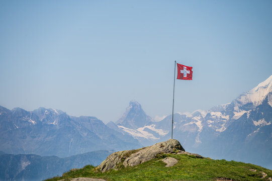 Swiss flag with view on the Matterhorn in the distance