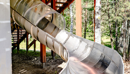 Children's slide in the form of a pipe in an amusement park. Recreation and entertainment concept