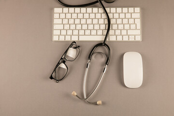 Stethoscope, glasses and keyboard on desktop