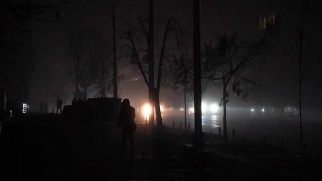 Blackout in the city. No street lightning. Light from cars during fog night.