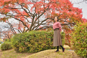 鴨川の土手の紅葉と女性