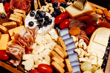 Obraz na płótnie Canvas Cheese platter, cheese board meat and board. Vegetables and fruits with cheese and chocolate, prosciutto and salami with bread. Big board of snacks for the party.
