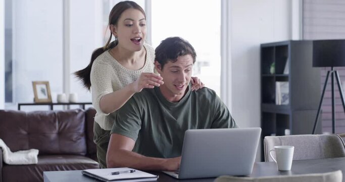 Freelance, laptop and man at table with woman interrupting, distracting or disturbing him at desk with remote work while working from home. Couple being playful in house with wife seeking attention